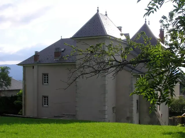 Façade du Château de Saint-Offenge et ses toits en tourelles, au milieu des arbres