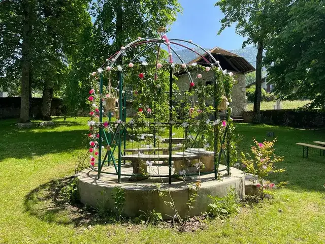 Gloriette en fer forgé couverte de roses dans le parc du château