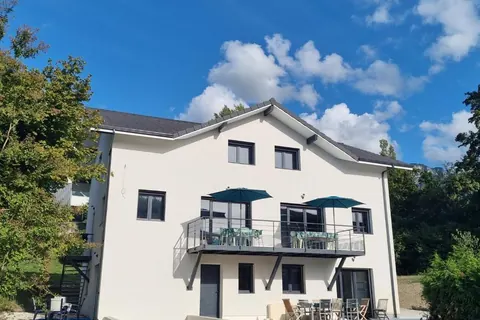 Façade blanche et balcon du gîte de groupe Le Combo