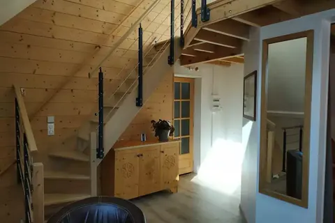 Escalier en bois et intérieur chaleureux de La petite clé des Bauges