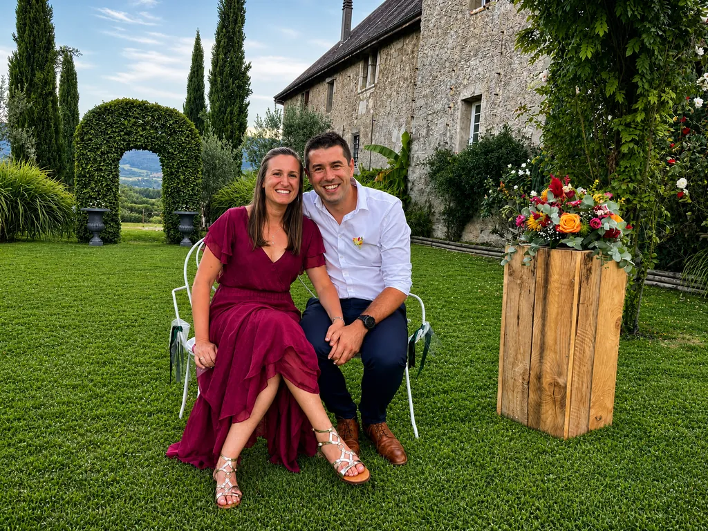Clémentine et Romain assis côte à côte dans un jardin fleuri, souriants