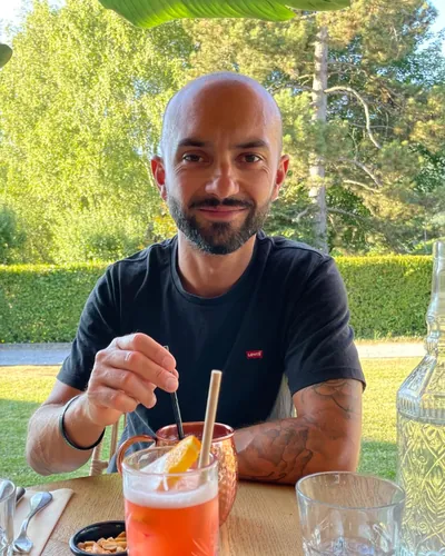 Portrait de Florent, souriant, attablé en terrasse